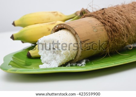 Popular South Indian breakfast puttu / pittu made of white rice flour and coconut in a bamboo mould, with banana, Kerala, India. Bamboo puttu prepared in the bamboo utensil. 