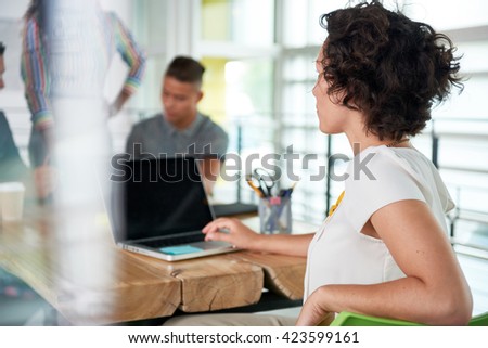 Image of a succesful casual business woman using laptop during meeting