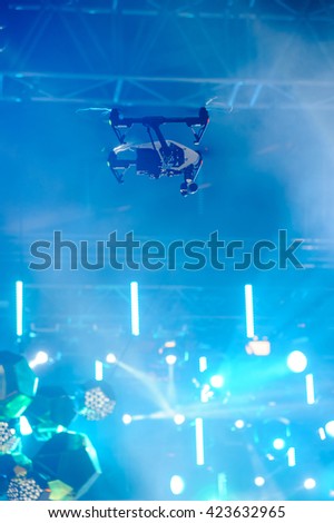 Professional camera drone flying over the scene during concert/Hovering drone on stage