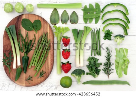 Red and green fresh super food with vegetable and fruit selection over distressed white wood background. High in vitamins, antioxidants, minerals and anthocyanins. Royalty-Free Stock Photo #423656452
