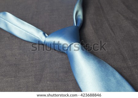 blue tie on a linen cloth
