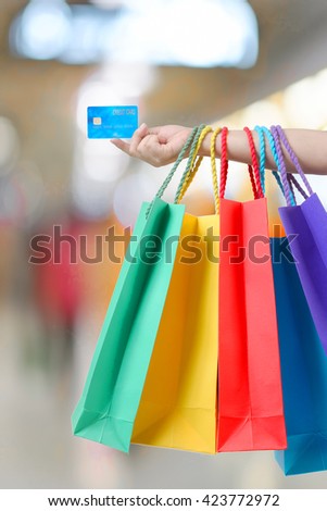 young woman hand with shopping bags and credit card.
