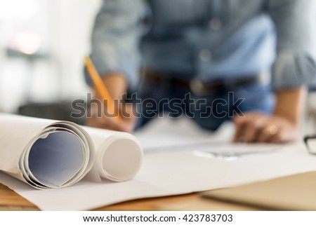 architect drawing on blueprint architectural concept, soft focus Royalty-Free Stock Photo #423783703