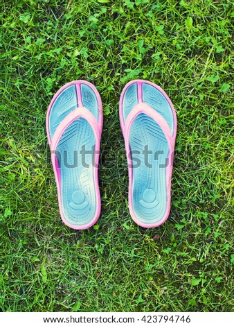 Women's Slippers are on the green grass.