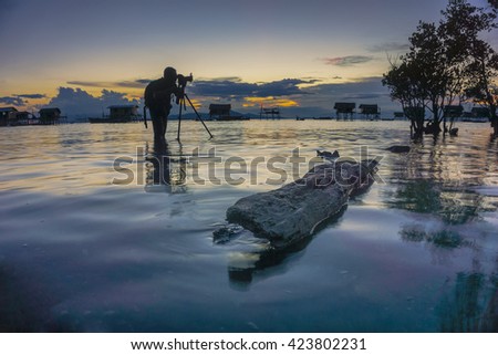 Silhouette a row of photographer with tripop camera in dramatic sunrise moment in Bogaya Island, Semporna Sabah