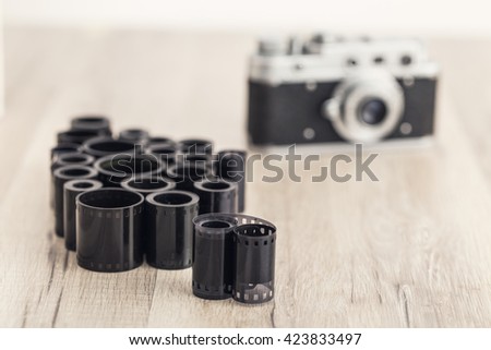 Old photo film rolls and old film camera on the background.
