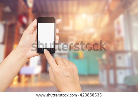 woman hand holding,using and touch smart phone,cell phone,mobile over blurred image of restaurant background,Transactions by smartphone concept