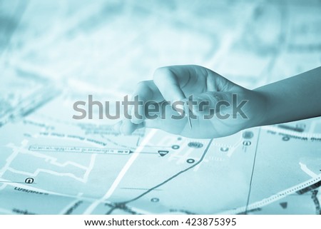 hand holding paper pin on blur perspective road map