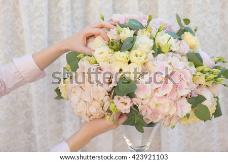Florist making beautiful bouquet of flowers. Hydrangea, Lisianthus, Eucalyptus, Rose, Peony.