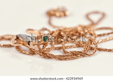 Gold chain and pendant in the form of a lizard with eyes of emeralds