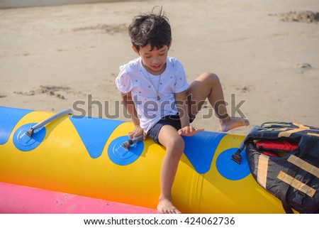 a boy climbing on banana boat