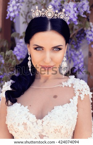 fashion outdoor photo of gorgeous woman in luxurious wedding dress posing at summer park