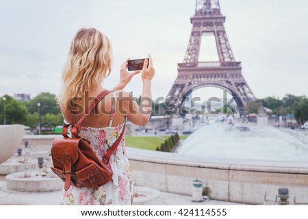 tourist taking photo of Eiffel tower in Paris with compact camera or smartphone, travel in  Europe Royalty-Free Stock Photo #424114555