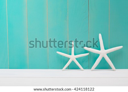 Two white starfish on a blue wooden background