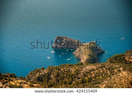 Beautiful landscape picture with rocky mountains and sailboats near the ring-shaped cliff, Mallorca, Spain.