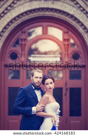 The newlyweds, the bride and groom at a wedding near the beautiful old doors