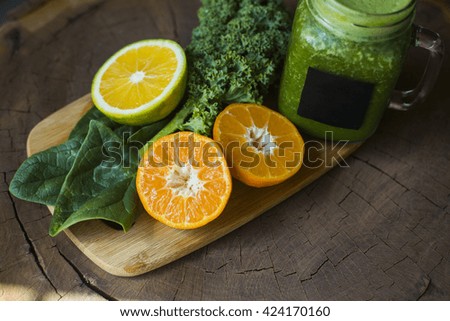 Spinach, kale and oranges next to a green juice