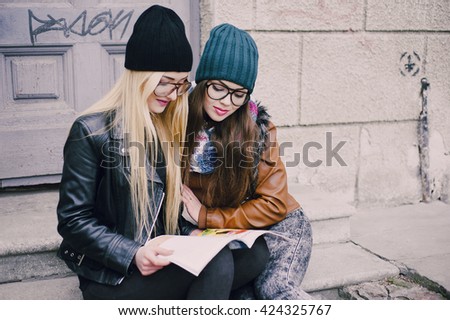 two beautiful girls walk around town fashionably and stylishly dressed
