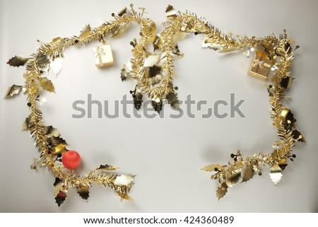 Christmas or New Year decoration background: fur-tree branches, colorful glass balls and glittering stars on white background, top view, copy space