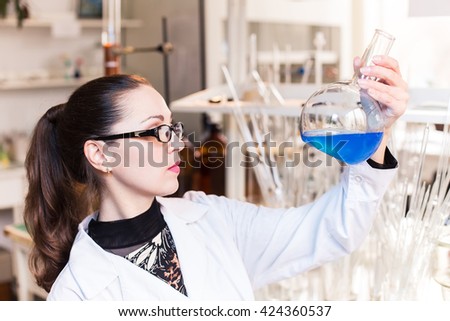 Woman scientist in laboratory studies fluid