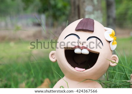 close up,ceramic smiling child with background in the garden,Happy dolls in the garden.