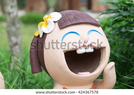 close up,ceramic smiling child with background in the garden,Happy dolls in the garden.