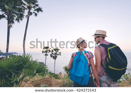 Traveling and trekking concept. Young loving couple walking on mountains near the sea.