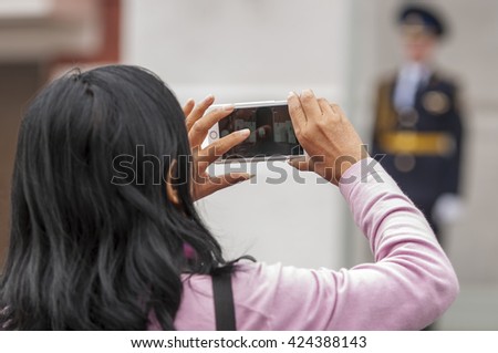 Closeup image on a female hands holding smartphone and taking a photo