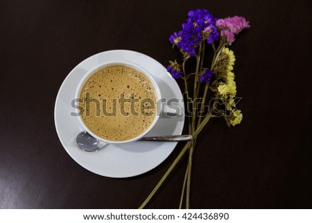 Cup of cappuccino art coffee with froth milk and flower and wooden background