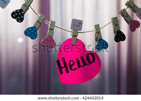 Hello message written on a paper hanging on the clothesline 