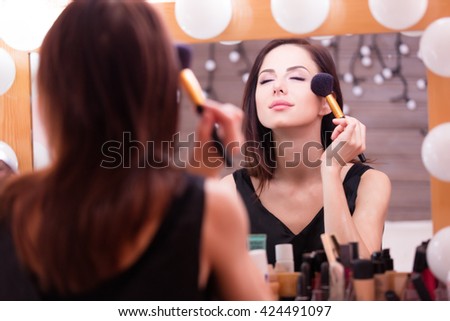 portrait of beautiful young woman doing makeup