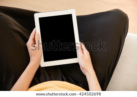 Cropped shot of female office worker holding digital tablet with blank copy space screen for your text or advertsing content. Housewife in casual clothes using electronic device for online shopping 