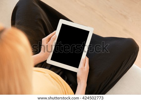 Young woman holding digital tablet with blank screen with copy space for your promotional content. Student girl messaging with friends via electronic gadget while relaxing after classes at university