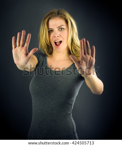 attractive woman on plein background shot in studio with soft lights with an interesting expression and dramatic lighting