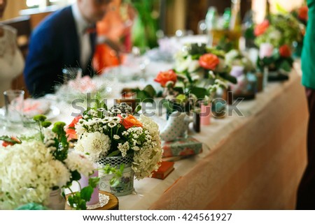 The veses of flowers are on the wedding table