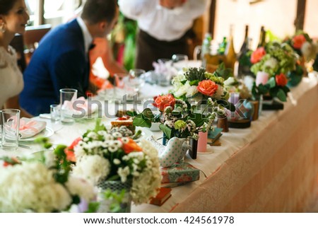 The veses of flowers are on the wedding table