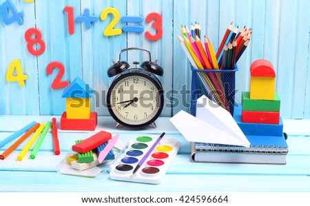 school supplies pencils crayons colorful assortment wooden background gentle blue tone(your text paper airplane wing) 