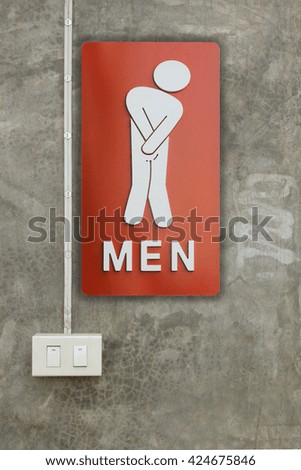Signs male bathroom and light switch was on the wall.