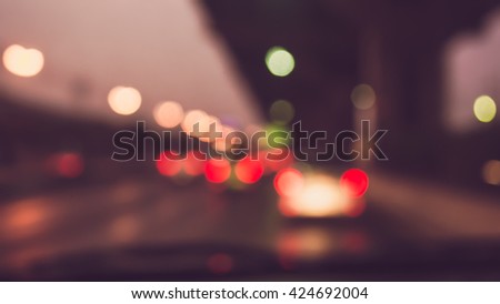 vintage tone blur image of inside cars with bokeh lights from traffic jam on night time for background.