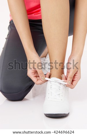 Close Up Of Asian young woman tying running shoes laces Isolated on white.