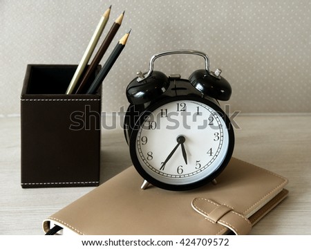 Decoration clock on table with pencil and book