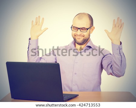 Funny photo of businessman bald with beard wearing shirt and glasses.  angry businessman working with laptop at table. Isolated on gray background 