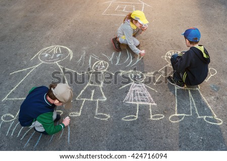 Children is drawing sun on asphalt in spring park. Royalty-Free Stock Photo #424716094