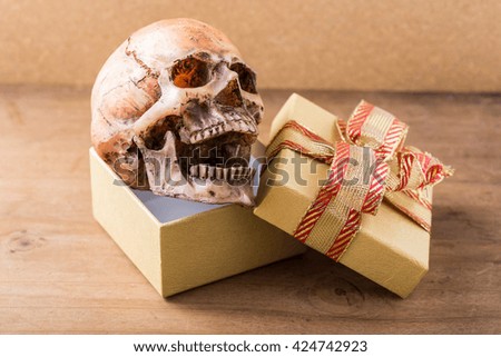 model skull with gift box on wooden background