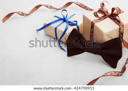 Gift or present box with ribbon and bowtie on gray desk for Happy Fathers Day, copy space for your text or design