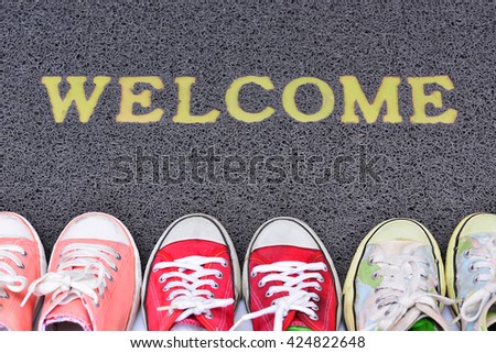 Welcome carpet with foot-ware on it
