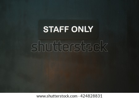 "Staff Only" door on the grey brick wall background.