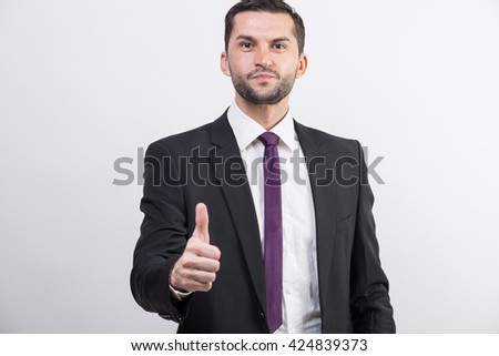 Young businessman in a suit with thumb up