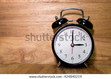 Vintage background with retro alarm clock on wood background, Alarm clock shows Three o`clock
