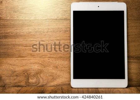 Tablet computer on wooden background
